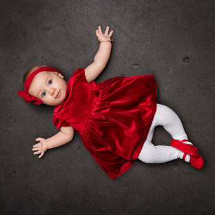 Baby im roten Kleid im Fotostudio