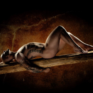 Männerakt - Nackter Mann auf Holzbalken im Fotostudio