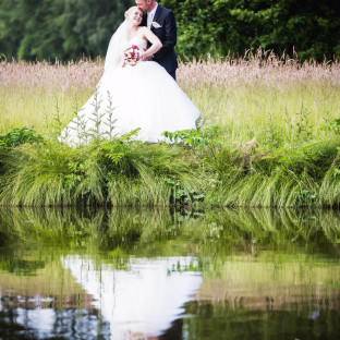Brautpaar spiegelt sich im Wasser in Glinde